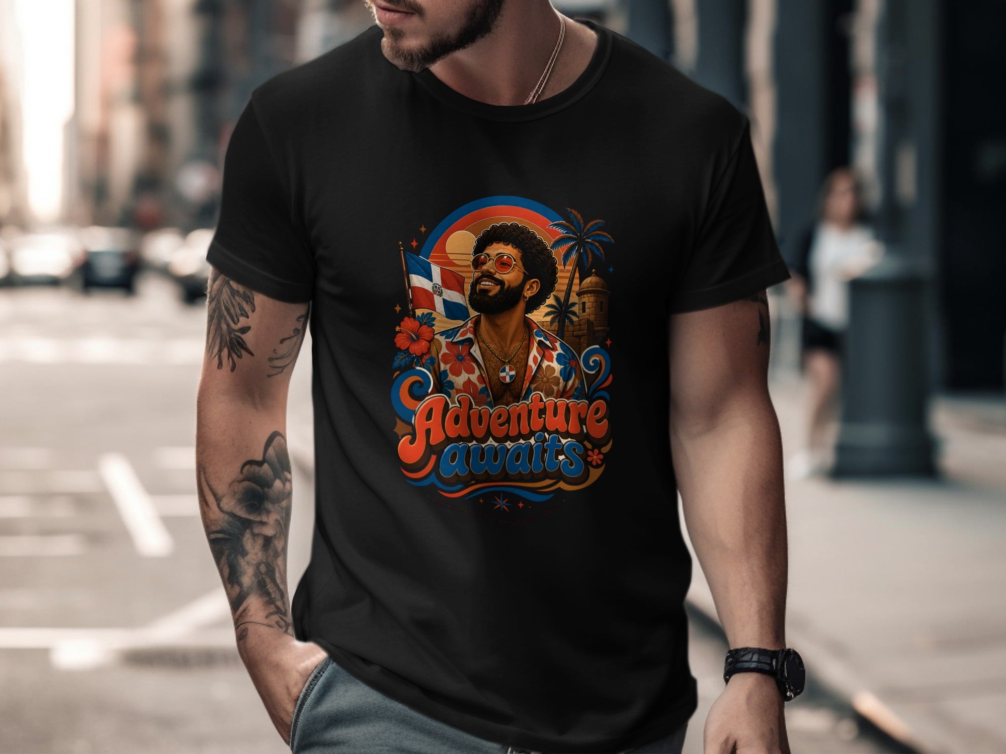 Black t-shirt with colorful graphic of man, sun, and palm trees reading "Adventure awaits".