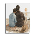 Two figures seated on a blanket on a beach facing the ocean and a setting sun.