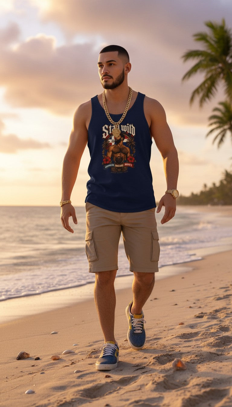 Oso Caribeño navy blue graphic tank top featuring Stay Wild Dominican pride design worn by a man on a beach