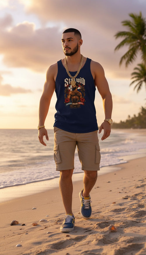 Oso Caribeño navy blue graphic tank top featuring Stay Wild Dominican pride design worn by a man on a beach